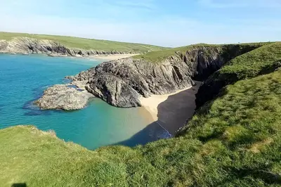 an aerial view of a beach with rocks and water at Sunny holiday house in Newquay