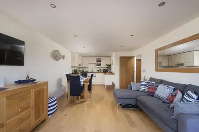 a living room with a couch and a kitchen at 5 Sandy Lane Apartments, Carbis Bay in Carbis Bay