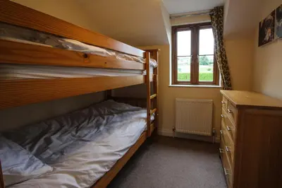 a bedroom with two bunk beds and a window at Gardenia Cottage Cornwall in Wadebridge
