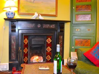 a bottle of wine sitting on a table next to a fireplace at 3 Bed in Polruan oc-pc032 in Fowey
