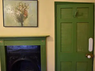 a green door with a painting above a fireplace at 3 Bed in Polruan oc-pc032 in Fowey