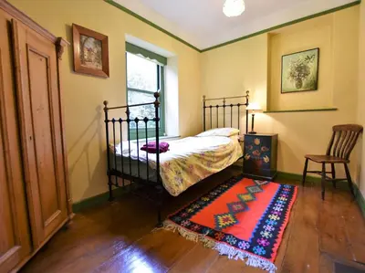 a bedroom with a bed and a rug and a window at 3 Bed in Polruan oc-pc032 in Fowey