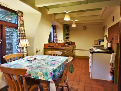a kitchen with a table and chairs and a kitchen with a table and a counter at 3 Bed in Polruan oc-pc032 in Fowey