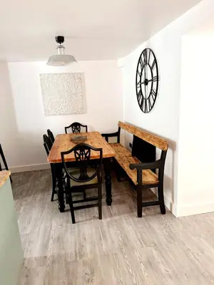 a dining room with a table and chairs and a clock at 13 WinterSlow Cottage in St Ives