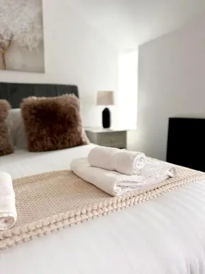 a bed with two towels sitting on top of it at 13 WinterSlow Cottage in St Ives