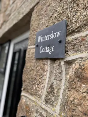 a sign on the side of a brick building at 13 WinterSlow Cottage in St Ives