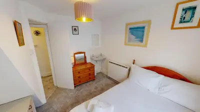 a bedroom with a white bed and a mirror at St Ives Gazelle Cottage 2 Bedrooms in St Ives