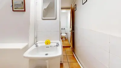 a white bathroom with a sink and a mirror at St Ives Gazelle Cottage 2 Bedrooms in St Ives