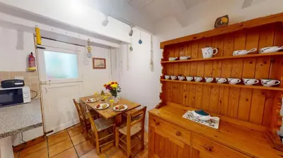 a kitchen with a small table and a kitchen with a counter at St Ives Gazelle Cottage 2 Bedrooms in St Ives