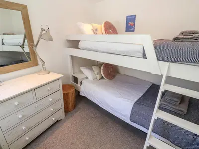 a bedroom with two bunk beds and a mirror at Cormorant Cottage in St Ives
