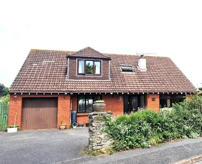 a red brick house with a window and a driveway at Wadebridge, 14 St Matthews Hill in Wadebridge