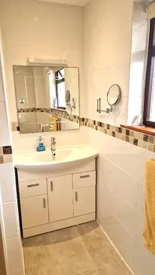 a white bathroom with a sink and a mirror at Wadebridge, 14 St Matthews Hill in Wadebridge