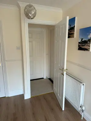 a hallway with a white door and a chandelier at Wadebridge, 14 St Matthews Hill in Wadebridge