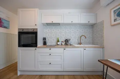 a kitchen with white cabinets and a sink at St Ives apartment less than 5 minutes walk to beach parking available in St Ives