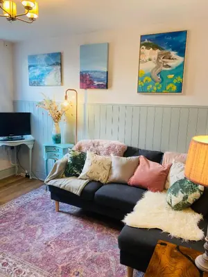 a living room with a couch and a tv at St Ives apartment less than 5 minutes walk to beach parking available in St Ives
