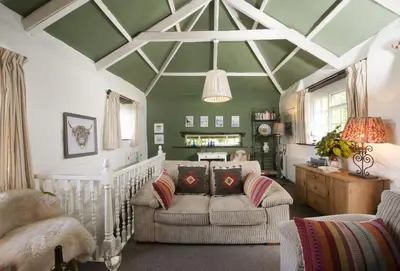 a living room with a couch and chairs and a ceiling at The Watermill in Bodmin