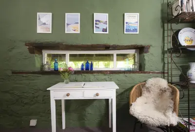 a white table and a chair and a window at The Watermill in Bodmin