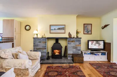 a living room with a fireplace and a couch at Stradav in Polzeath