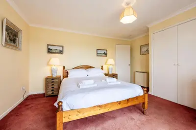 a bedroom with a large bed and two lamps at Stradav in Polzeath