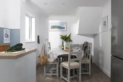 a kitchen and dining room with a table and chairs at Castaways in Porthtowan