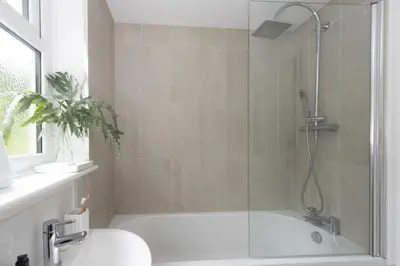 a bathroom with a shower and a toilet and a tub at Castaways in Porthtowan