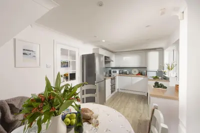 a kitchen and dining room with a table and chairs at Castaways in Porthtowan