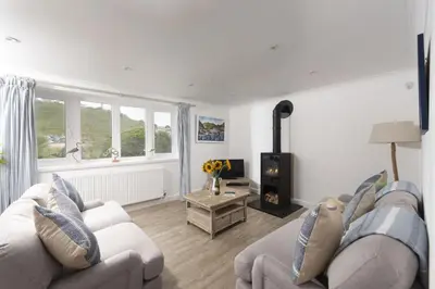 a living room with a couch and a fireplace at Castaways in Porthtowan