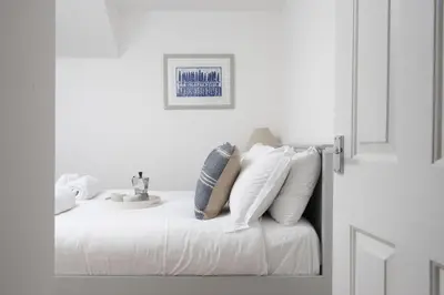 a white bedroom with a bed with a sink at Castaways in Porthtowan