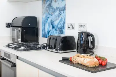 a kitchen with a counter top with a cutting board with a turkey at The Penthouse, 48 Zinc in Newquay