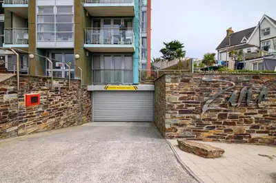 a brick wall with a garage and a building at The Penthouse, 48 Zinc in Newquay
