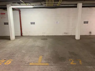 an empty parking garage with white walls and white columns at The Penthouse, 48 Zinc in Newquay