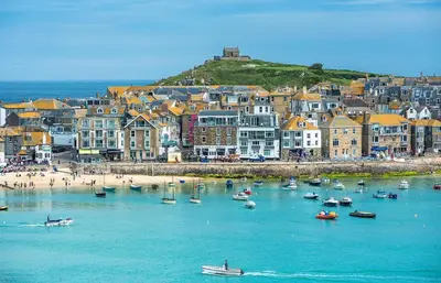 a group of boats in the water near a beach at Henrys in St Ives