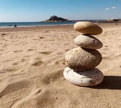 a stack of rocks sitting on a beach at Henrys in St Ives