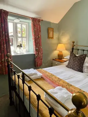 a bedroom with a bed and a window at The Old Wood Store in Helston