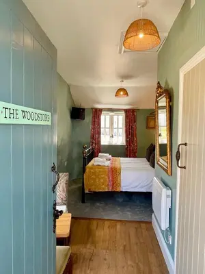 a bedroom with a bed and a window at The Old Wood Store in Helston