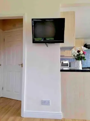 a television on top of a wall in a kitchen at Spacious cabin, near Padstow and 7 Bays in St Merryn