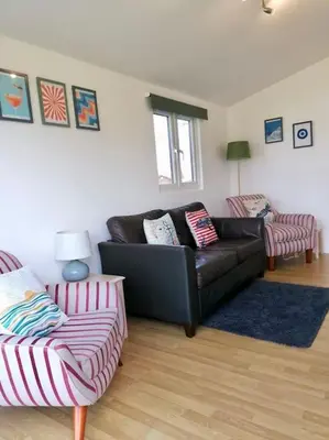 a living room with a couch and two chairs at Spacious cabin, near Padstow and 7 Bays in St Merryn