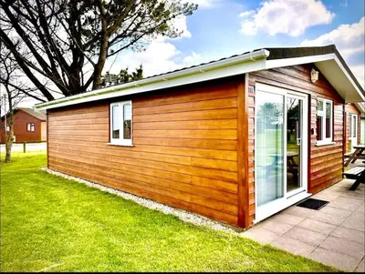 a small cabin with a window on the grass at Spacious cabin, near Padstow and 7 Bays in St Merryn