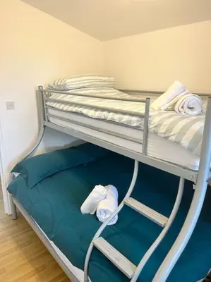a bunk bed with towels on the bottom bunk at Spacious cabin, near Padstow and 7 Bays in St Merryn