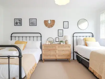 a bedroom with two beds and a dresser at Polwen in Padstow