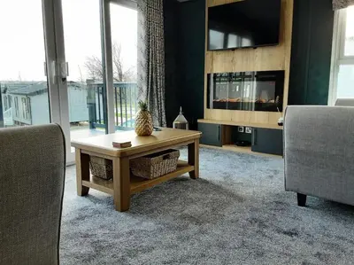 a living room with a table and two chairs at Holiday Home with a Hot tub in St Austell