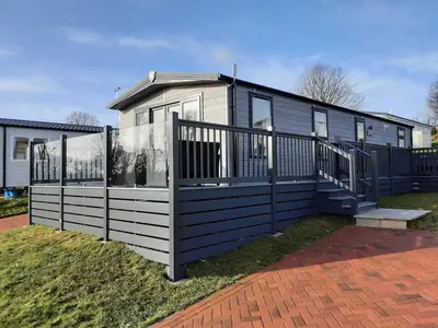 a house with a black and white fence at Holiday Home with a Hot tub in St Austell