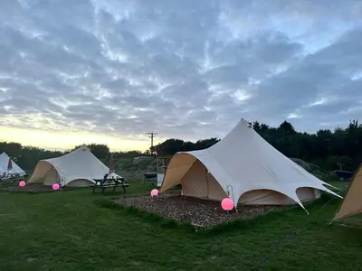 a group of tents sitting in a field at Tylda Tents at Tregonetha Lake - 5m Luxury Bell Tent 