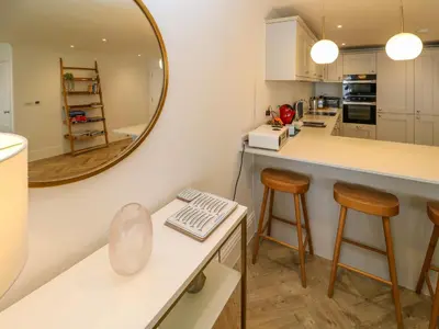 a kitchen with a counter and stools and a mirror at Amelia's Point in St Ives