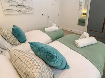 a room with three beds with blue and white pillows at Amelia's Point in St Ives