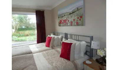 a bedroom with a bed with red and white pillows at Seven Bed and Breakfast in St. Agnes