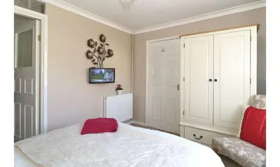 a bedroom with a white bed with a red bag on it at Seven Bed and Breakfast in St. Agnes