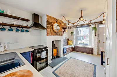 a kitchen with a stove and a fireplace at 2 Bed in Looe oc-a29612 in Looe