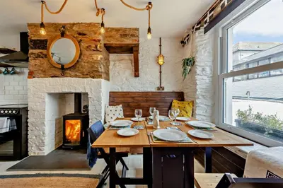 a dining room with a table and a fireplace at 2 Bed in Looe oc-a29612 in Looe
