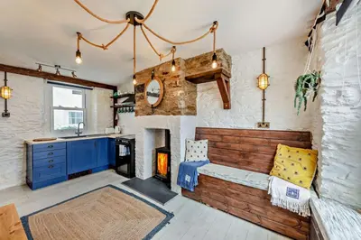 a living room with a fireplace and a couch at 2 Bed in Looe oc-a29612 in Looe